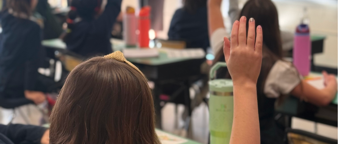 Students in class raising hand